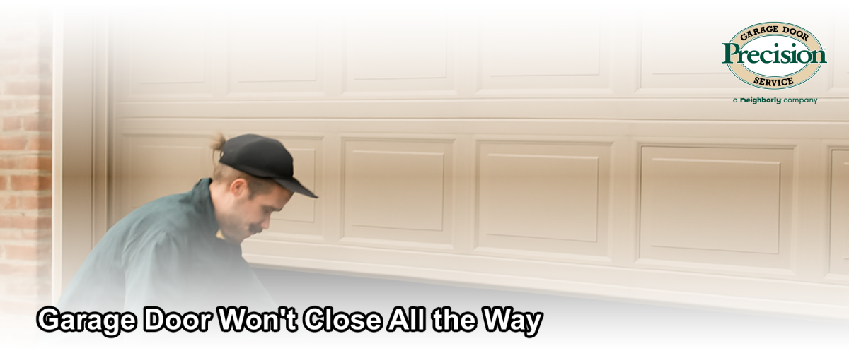 Garage door stopped partway open on a residential home in Brick Township NJ with a technician inspecting the tracks