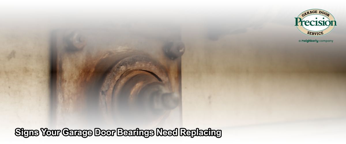 Close-up of a worn garage door bearing plate and torsion spring assembly showing signs of rust and wear